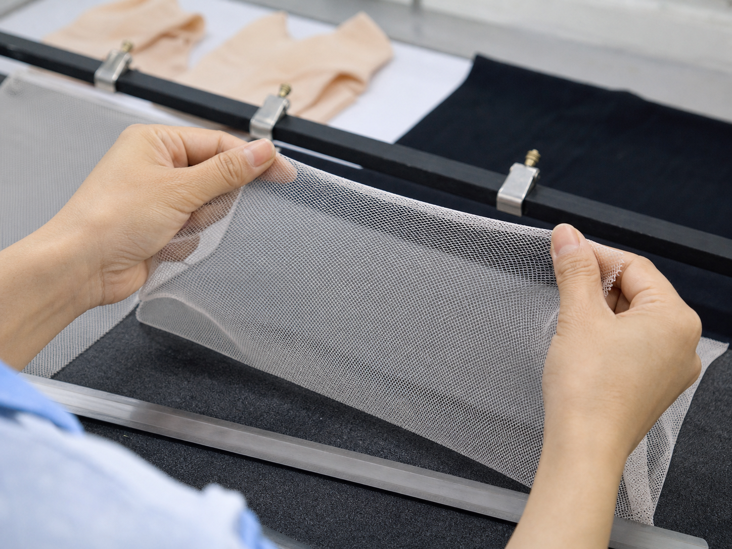 Mesh fabric stretch recovery check at an inspection bench